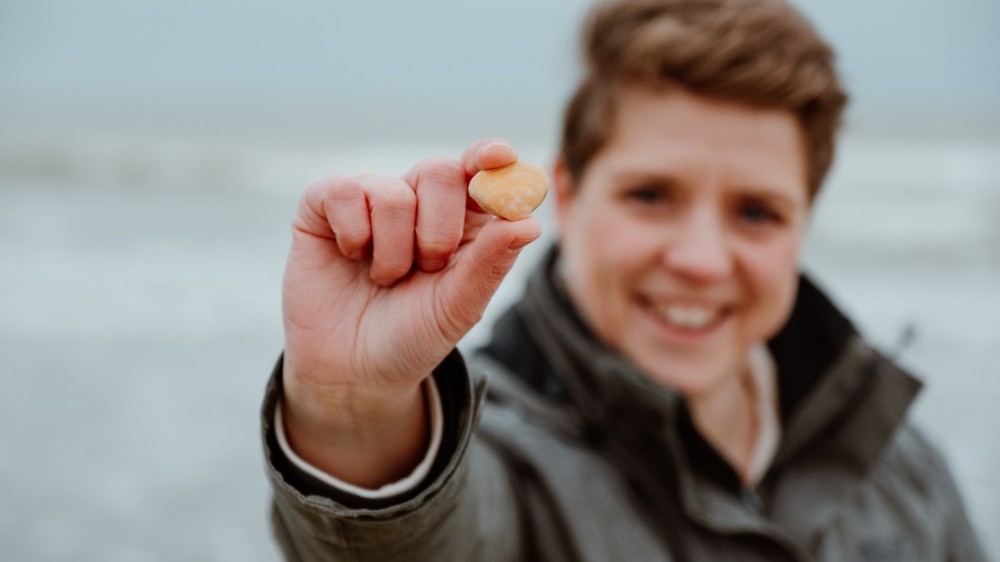 Ambassadrice van de Grote Schelptenteldag, Hetty Helsmoortel, met de winnende schelp: de Halfgeknotte strandschelp.